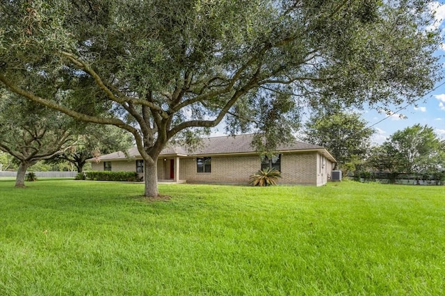 ranch-style home featuring central air condition unit and a front yard