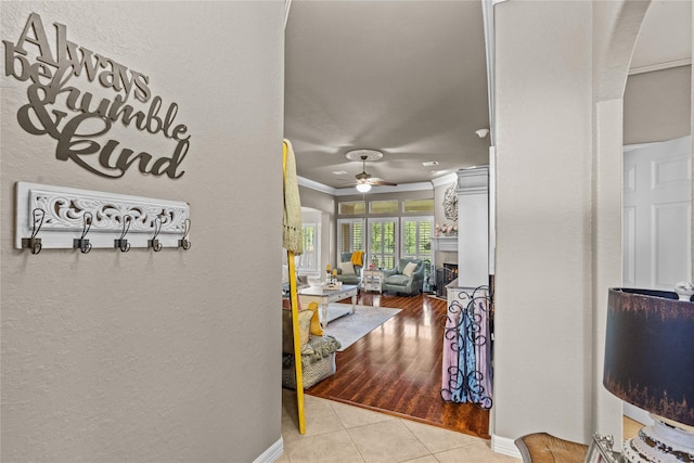 hallway with crown molding and light tile patterned floors