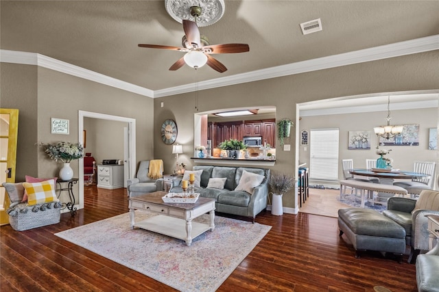 living room featuring ceiling fan with notable chandelier, dark hardwood / wood-style floors, ornamental molding, and a textured ceiling