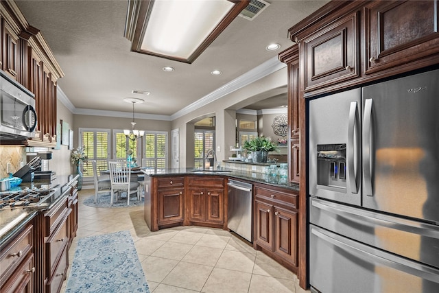 kitchen featuring an inviting chandelier, sink, light tile patterned floors, appliances with stainless steel finishes, and decorative light fixtures