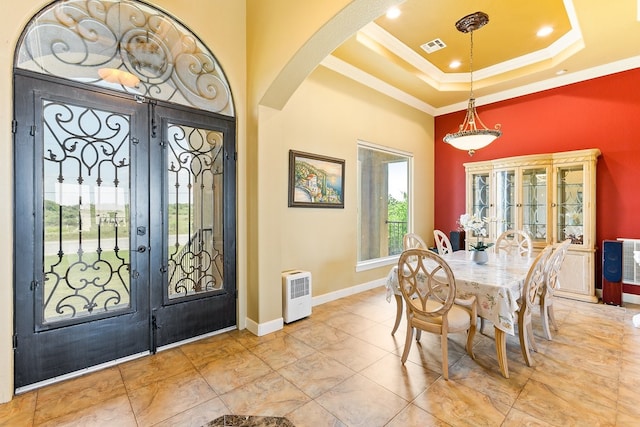 dining area featuring a tray ceiling, crown molding, and french doors