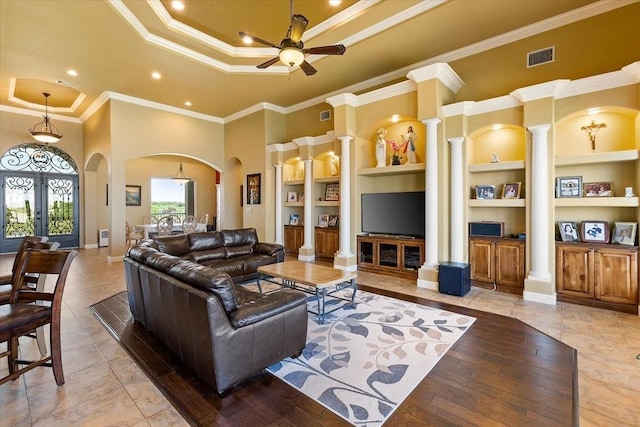 living room with built in shelves, french doors, crown molding, and ceiling fan