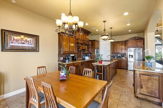 dining space featuring a notable chandelier and sink