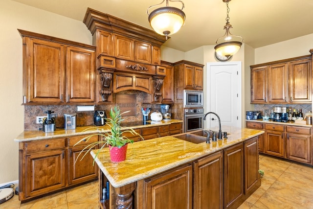 kitchen with decorative backsplash, a center island with sink, stainless steel appliances, and sink