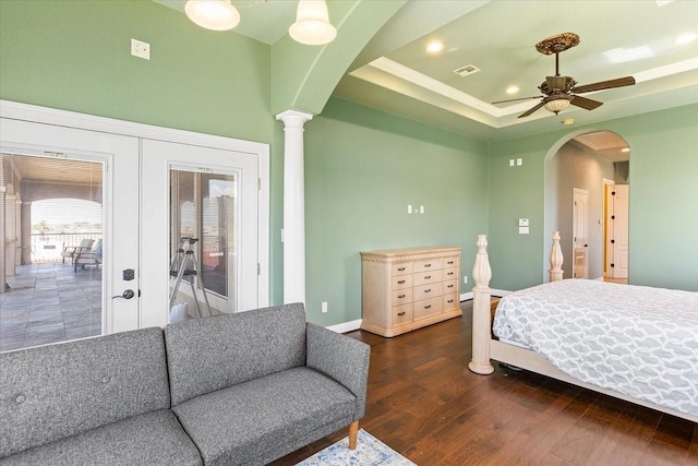 bedroom with dark wood-type flooring, access to outside, french doors, ceiling fan, and ornate columns