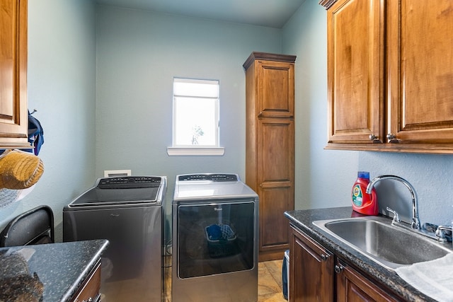 laundry room with washer and dryer, light tile patterned flooring, cabinets, and sink