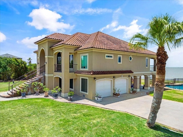 view of front facade with a water view, a front yard, and a garage