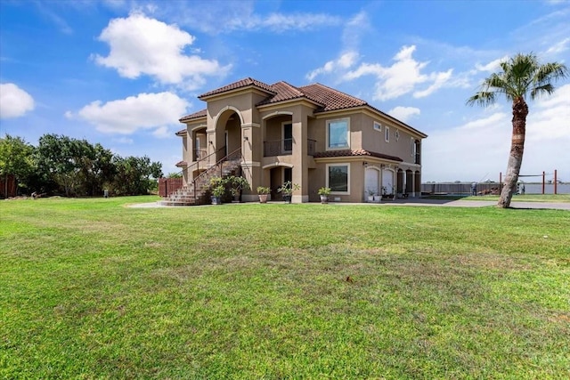 mediterranean / spanish-style house featuring a front yard and a garage