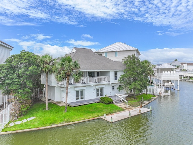 back of property featuring a yard, a balcony, a deck with water view, and french doors