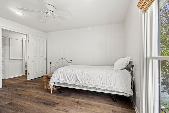 bedroom with multiple windows, ceiling fan, and dark wood-type flooring