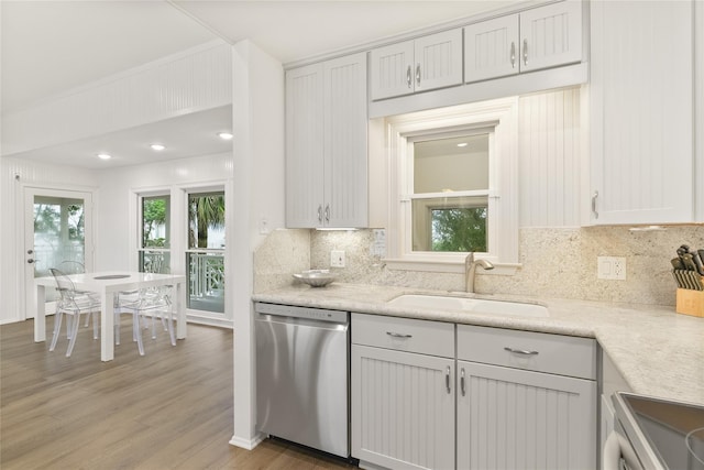 kitchen with light wood-type flooring, backsplash, stainless steel dishwasher, sink, and range