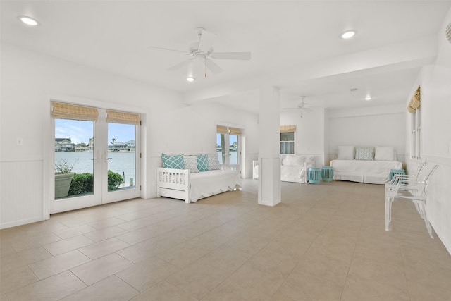 unfurnished bedroom featuring ceiling fan, a water view, light tile patterned floors, and access to outside