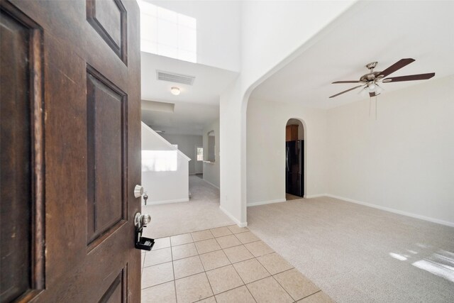 carpeted entrance foyer featuring ceiling fan