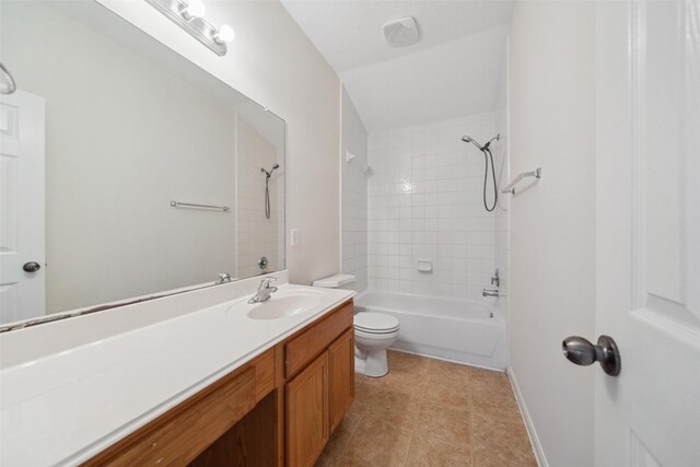 full bathroom featuring tile patterned floors, vanity, tiled shower / bath combo, and toilet