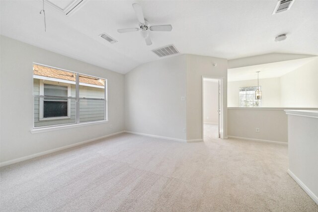 carpeted spare room with ceiling fan and vaulted ceiling