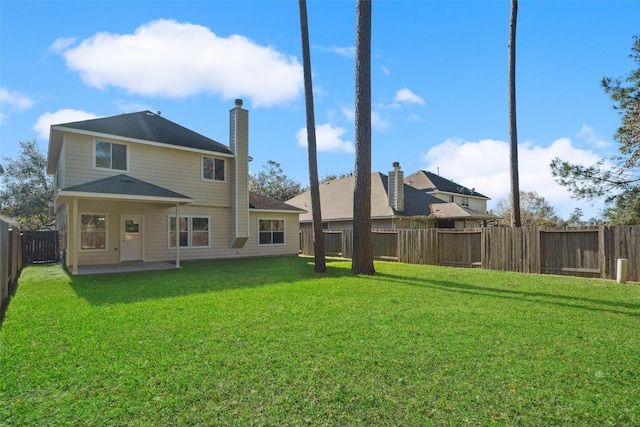 back of house featuring a patio area and a yard