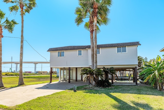 rear view of property with a yard and a carport