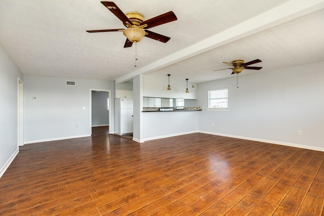 unfurnished living room featuring beam ceiling, a textured ceiling, dark hardwood / wood-style floors, and ceiling fan