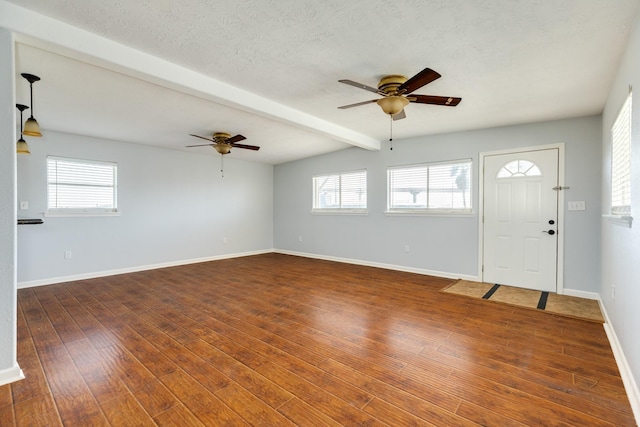 foyer entrance with vaulted ceiling with beams, ceiling fan, and dark wood-type flooring