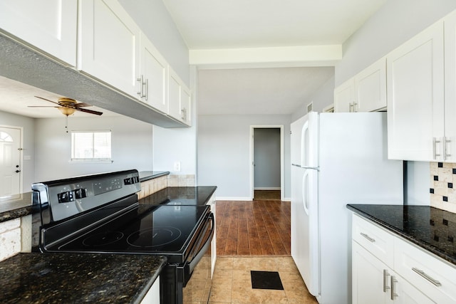 kitchen featuring ceiling fan, dark stone countertops, black electric range, white fridge, and white cabinetry