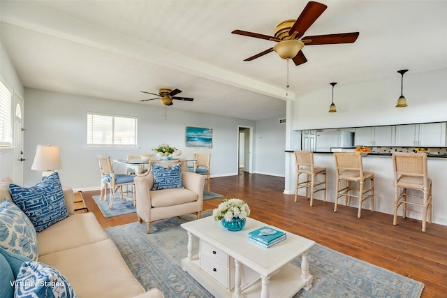 living room with beam ceiling, ceiling fan, and dark wood-type flooring