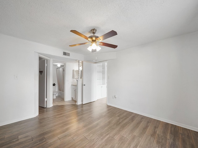 unfurnished room with ceiling fan and a textured ceiling