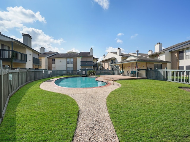 view of pool with a lawn and a patio