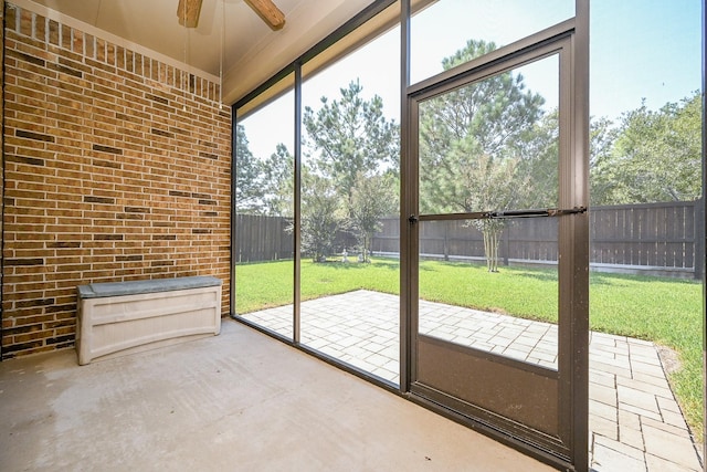 unfurnished sunroom featuring ceiling fan