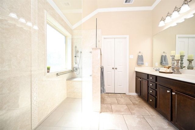 bathroom featuring a tile shower, crown molding, tile patterned flooring, and vanity