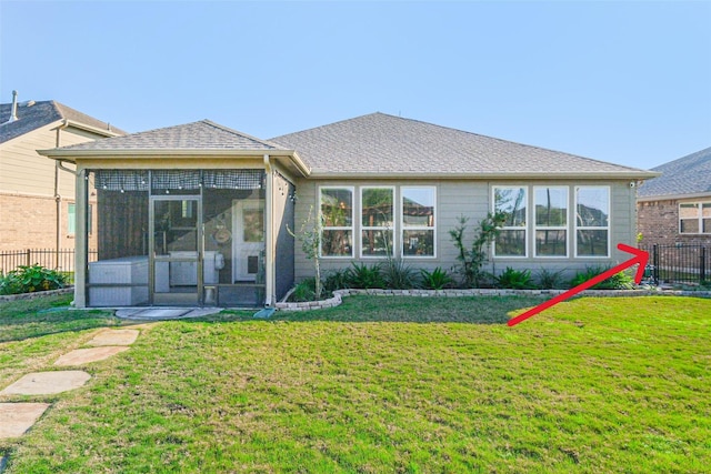 back of property with a sunroom and a yard