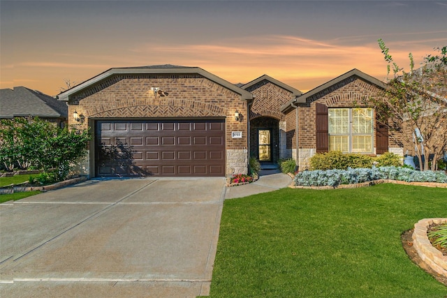 view of front of property featuring a garage and a lawn