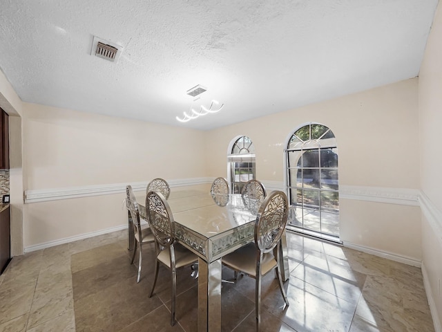 dining space featuring a textured ceiling