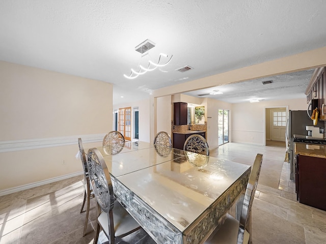 dining area with light tile patterned floors and a textured ceiling