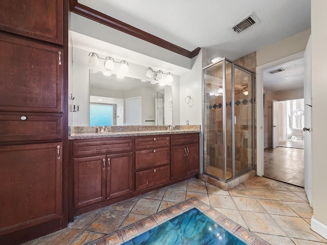 bathroom featuring tile patterned flooring, vanity, and a shower with door