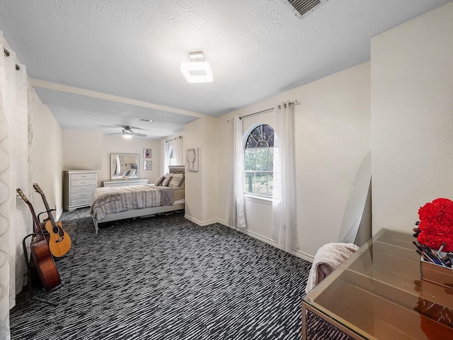 bedroom with dark carpet and a textured ceiling