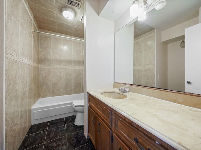 full bathroom with vanity, toilet, and tiled shower / bath