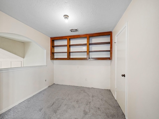 empty room featuring light colored carpet and a textured ceiling