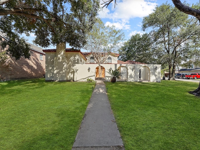 mediterranean / spanish-style house with a front yard