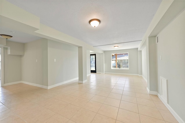 tiled empty room with a textured ceiling