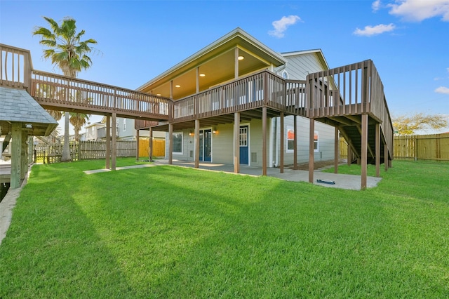 back of house featuring a yard, a patio, and a deck