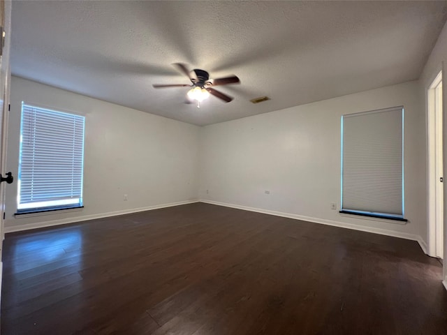 spare room featuring dark hardwood / wood-style flooring, a textured ceiling, and ceiling fan