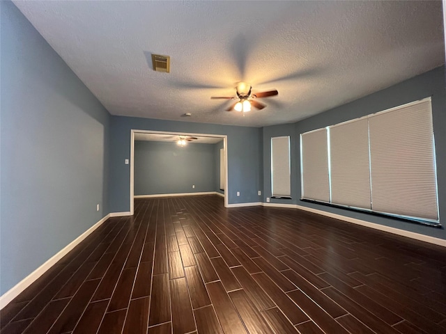 spare room featuring a textured ceiling, ceiling fan, and dark wood-type flooring