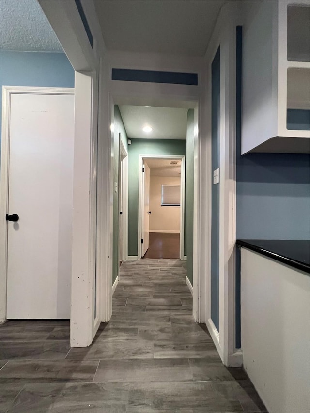 hallway featuring a textured ceiling and hardwood / wood-style flooring