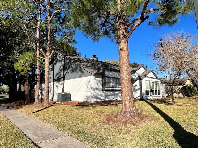 view of front of house with central AC and a front yard