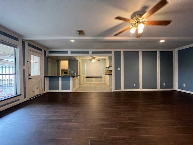 unfurnished living room featuring ceiling fan, dark hardwood / wood-style flooring, and a textured ceiling