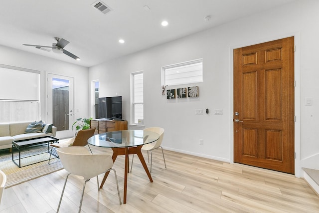 dining area with light wood-type flooring, plenty of natural light, and ceiling fan