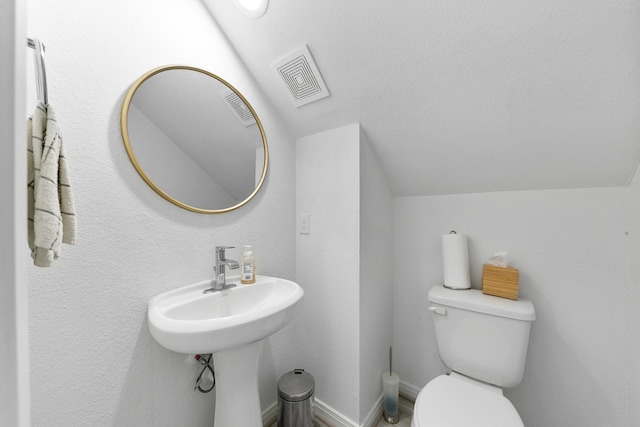 bathroom with vaulted ceiling and toilet