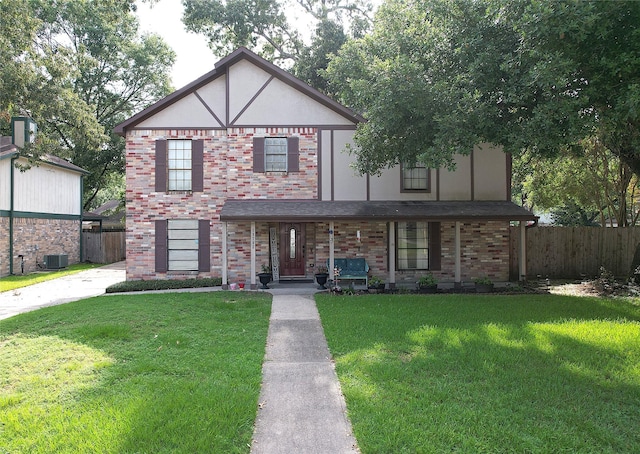 tudor-style house featuring a front yard and central AC