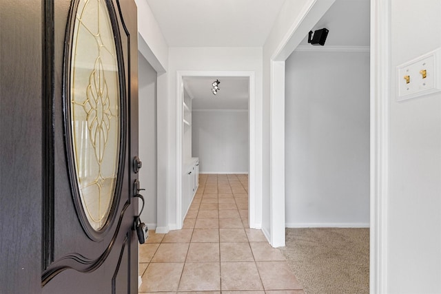 hall with light tile patterned floors and ornamental molding