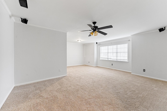 spare room featuring light carpet, crown molding, and ceiling fan